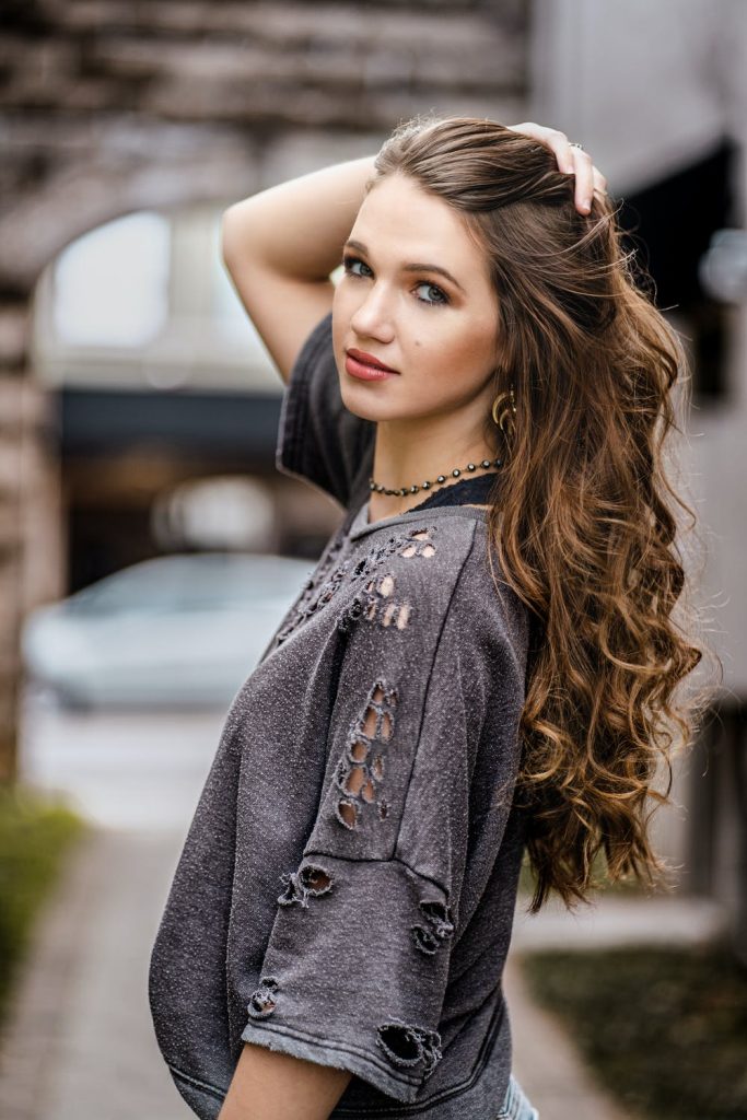 Free Photo | Woman in orange sweater sits on street road. charming girl in  jeans posing outside near bloomimg sakura. lady looking into camera